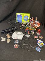 Full set of Kinect sensor, USB cable, Disney Infinity game disc and case, game base, character figures, and power discs.