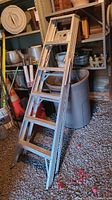 Full view of the 6-foot aluminum painter's ladder leaning against shelving.