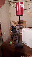 Brass candlestick holder and pedestal candle holder with a red pillar candle on top