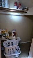 Photo showing laundry baskets, stacks of solo cups on a shelf, and light bulb boxes
