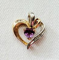 Front view showing the heart shaped pendant with yellow and white gold and the central amethyst with diamond accents.