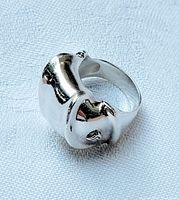 Angled top view showing the ring's chunky, curved design with polished silver surface.