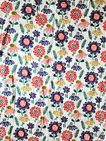 Full view of the fabric showing colourful flower print pattern on white background.