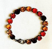 Top down view of bracelet displaying round faceted crystals in shades of orange and gold arranged uniformly.