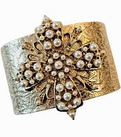 Close-up front view of the gold tone cuff bangle bracelet with clustered faux pearls in floral cross pattern.