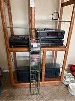 Overview of the lot on wooden glass shelf rack showing turntable, receiver, disc player, speakers, CD rack with CDs.