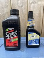 Single 1-liter bottle of Castrol Syntec 5W50 beside a 325 ml bottle of Wynns Fuel Stabilizer showing labels clearly