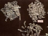 Assorted clear crystals in elongated and irregular shapes spread on dark surface with lot #46 tag