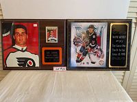 Two framed hockey plaques side by side on a table - Eric Lindros on left, Wayne Gretzky on right