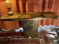 Full view of the slate table showing the rectangular tiled top and solid base with natural stone textures in earth tones.