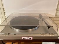 Full view of JVC turntable with clear plastic dust cover showing scratches.