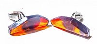 Pair of mid century amber cufflinks showing the amber stones and silver-tone metal wings on the back used for securing them.