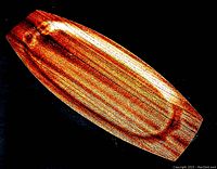 Top view of mid century teak tray showing wood grain and elongated rectangular shape with tapered ends.