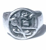 Close-up front view of vintage silver ring showing embedded Asian motif design on circular face.
