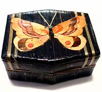 Top view of the vintage wooden box showing the butterfly motif on the lid with wood inlay, black shiny finish visible.