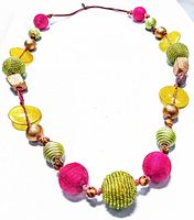 Full view of the vintage necklace showing round pink and lime green cotton beads, yellow lucite disc beads, and small copper-tone beads on a brown-red cord.
