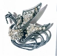 Front view of vintage gunmetal brooch with clear rhinestones embellished on textured metal surface and twisted details.