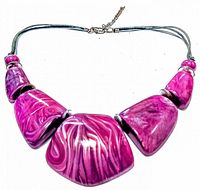 Front view of vintage pink resin necklace showing five large beads with swirled pink patterns on a grey cord with metal clasp.