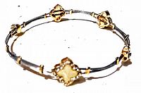 Top-down clear photo of the entire vintage rhinestone bangle showing gold-tone settings with square and crown rhinestones on a silver-tone textured band.