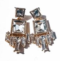 Front view of the vintage rhinestone earrings showing the large square, rectangular, and smaller rhinestones on gold-tone metal settings.