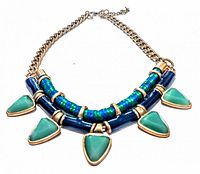Photo showing the necklace laid flat displaying the gold tone chain, turquoise-colored triangular stone pendants, blue beads, and extender chain.