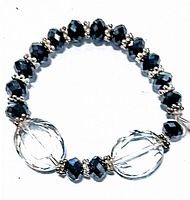 Photo of vintage stretch bracelet showing black faceted acrylic beads, clear oval acrylic beads with etched design and silver-tone spacer beads.