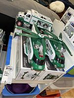 Photo of two Hess toy helicopters on top of boxes, with tags indicating two helicopters and trucks.