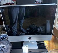 Front view of Apple 20-inch iMac computer model A1224 showing screen and aluminum frame with Apple logo under screen.