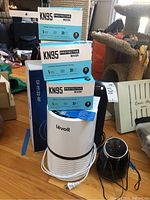 Shows four boxes of KN95 protective masks on and around the Levoit LV-H132 air purifier and part of black diffuser.