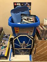 Blue Lego Star Wars storage tub with included items inside and Star Wars battle droids backpack in front