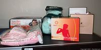 Lot items shown on tabletop: massage pillow, heating pad, neck pillow, derma roller set