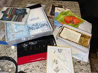 Full lot view showing Lanvin hand towels in box, Celine bag, folded silk scarves, paper fan, and boxed Nina Ricci handkerchief.