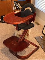 Full view of wooden high chair with attached tray and seat.