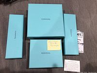 Four Tiffany & Co. boxes in various sizes on a grey surface