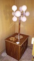 Full view of lamp on top of wood end table against paneled wall