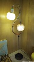Full view of S-shaped floor lamp showing both shades and base