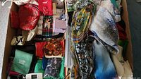 Top view showing various scarves folded and several small pouch bags arranged in a box