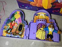 Miniature Beauty and the Beast fold-out playset with figurines of Belle and Beast inside purple plastic casing