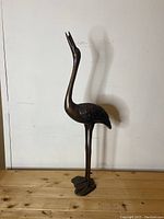 Full front view of heron on wooden surface against white background