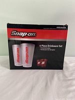 Box front showing Snap-On logo and image of the four piece drinkware set with frosted pint glasses and translucent red shot glasses.