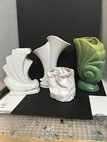 Four vintage decorative vases displayed together showing variety of styles and colors.