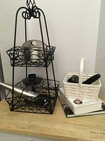 Full view of the kitchen lot items including the metal rack with handheld blender and mortar and pestle, basket with another mortar and pestle, and cookbooks.