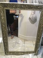 Full view of the rectangular mirror showing the reflective glass and ornate frame.