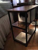Side table with wood top, black metal frame, and integrated cat cave beneath.