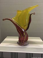 Front view of the hand-blown glass vase showing yellow and purple colors with flared top