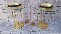 Pair of brass and thick glass UFO style table lamps showing front and side views on a patterned surface