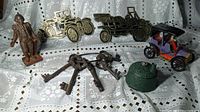 Full view of all listed items including cast iron bank, keys, pencil sharpener, toy car and metal plaques.