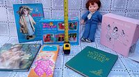 Complete view of the collection including doll, books, boxed doll set, and ballet box with measuring tape for scale.