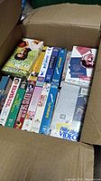 Open cardboard box filled with Elvis Presley VHS tapes stacked vertically showing spine titles and cover art.