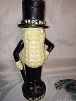 Front view of Mr. Peanut coin bank showing detailed paint and text on hat and base.